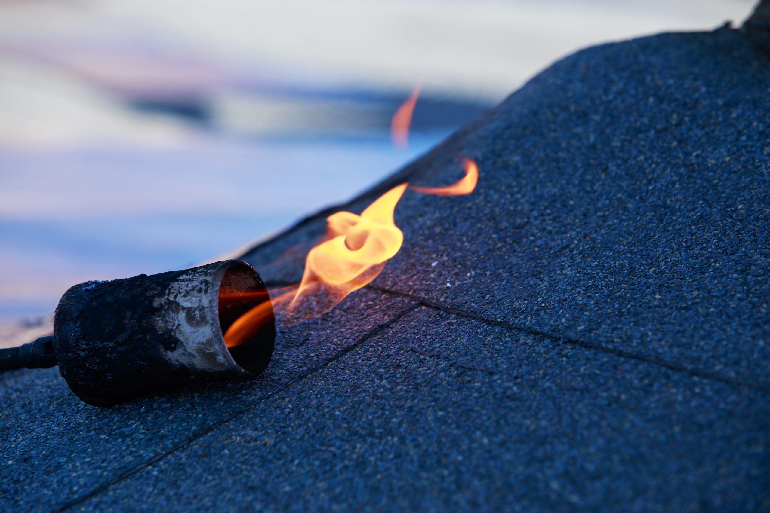 Brander met vlam op bitumineuze dakbedekking